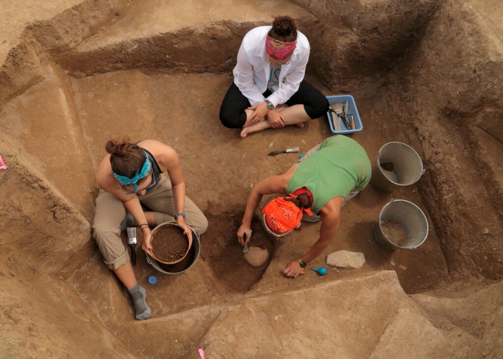 Elissa A Bullion and undergraduates at grave site dig.