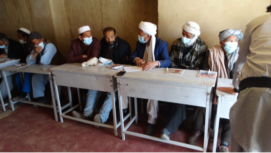 Men sit at desks during a workshop