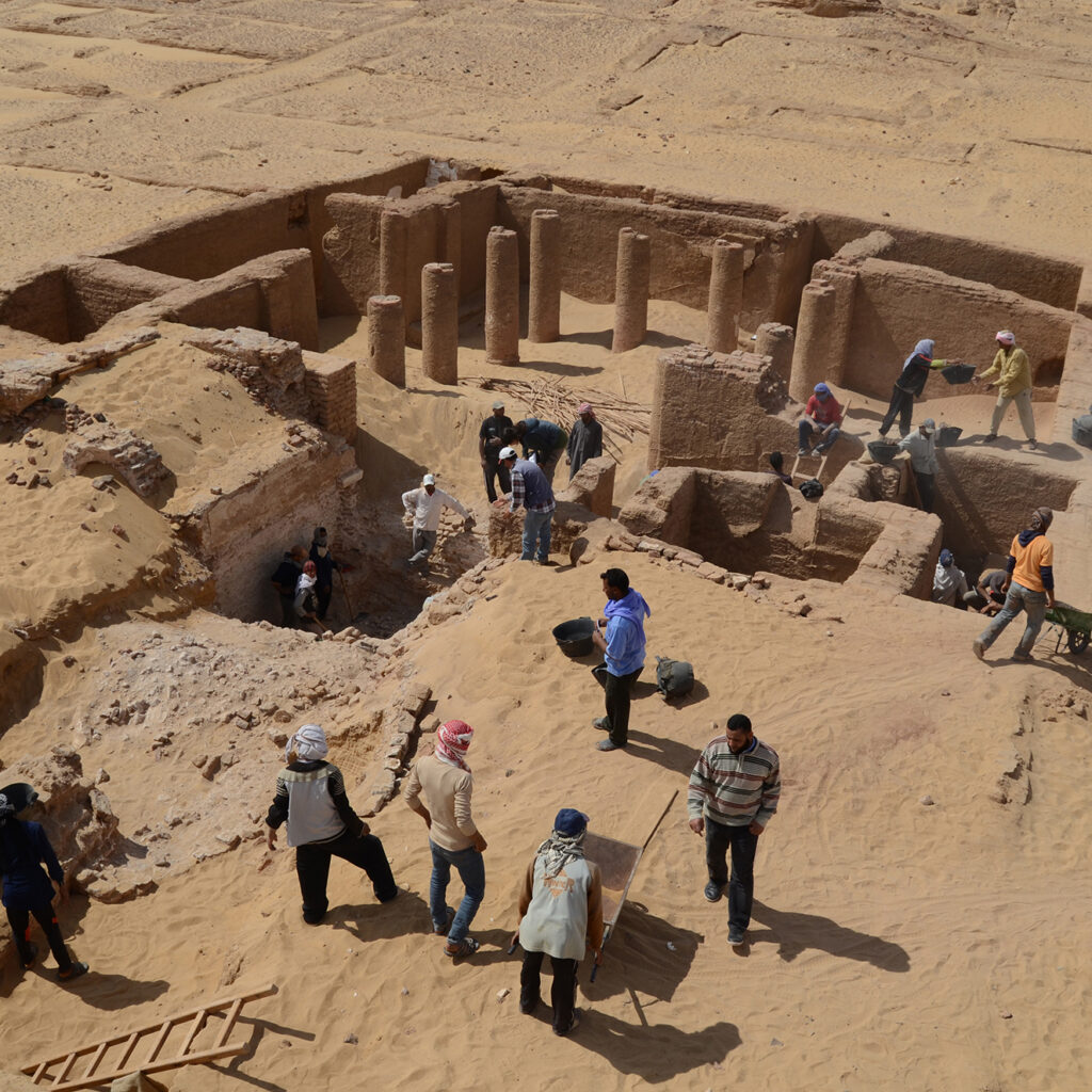 View of excavations in the Roman baths of Amheida from above as people explore the area 