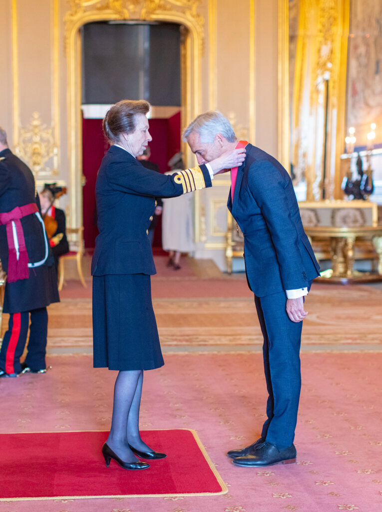 Russ Shaw bows as he receives a medal